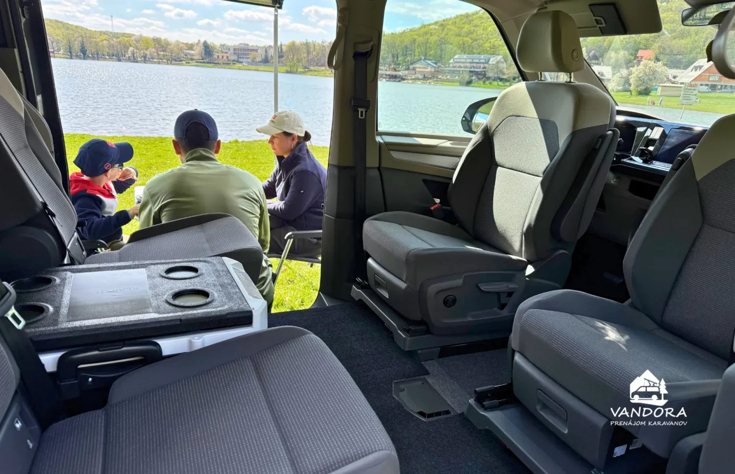 Interiér VW California T7 Beach Camper s výhľadom pri jazere