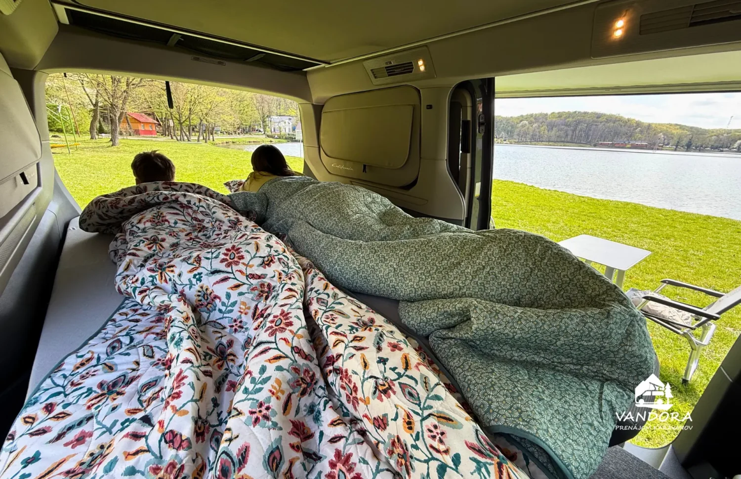 VW California T7 Beach Camper – výhľad na jazero zo spodného lôžka